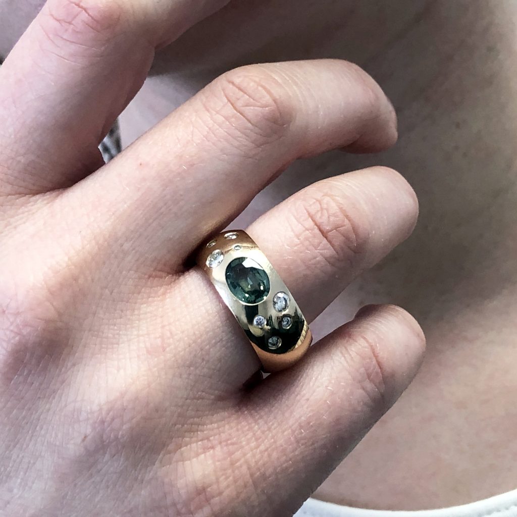 Ist das neu, oder ist das upcycling? 4 Ring mit Brillanten und grünem Safir an der Hand